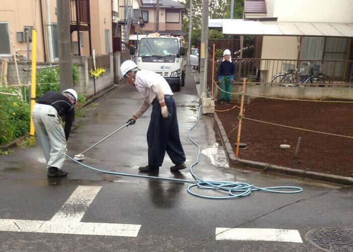 現場周辺の道路を清掃をする作業員